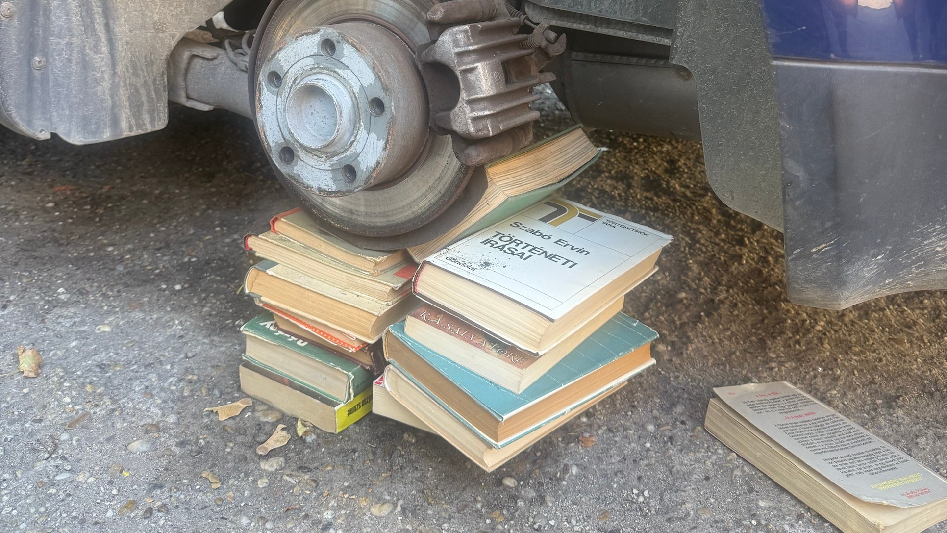 A Passat féktárcsája egy gondosan egymásra pakolt könyvhalmon pihen a kerék helyén