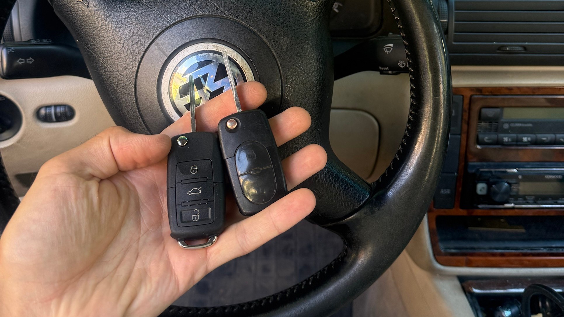Az új és a régi Volkswagen autókulcs a Passat kormánya előtt, a munka végeztével