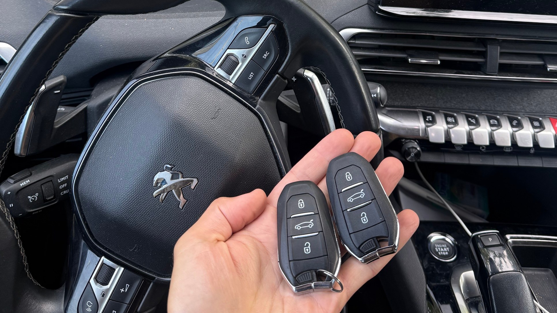 Két Peugeot keyless autókulcs a 2022-es Peugeot 5008 kormánya előtt, az elkészült munka után
