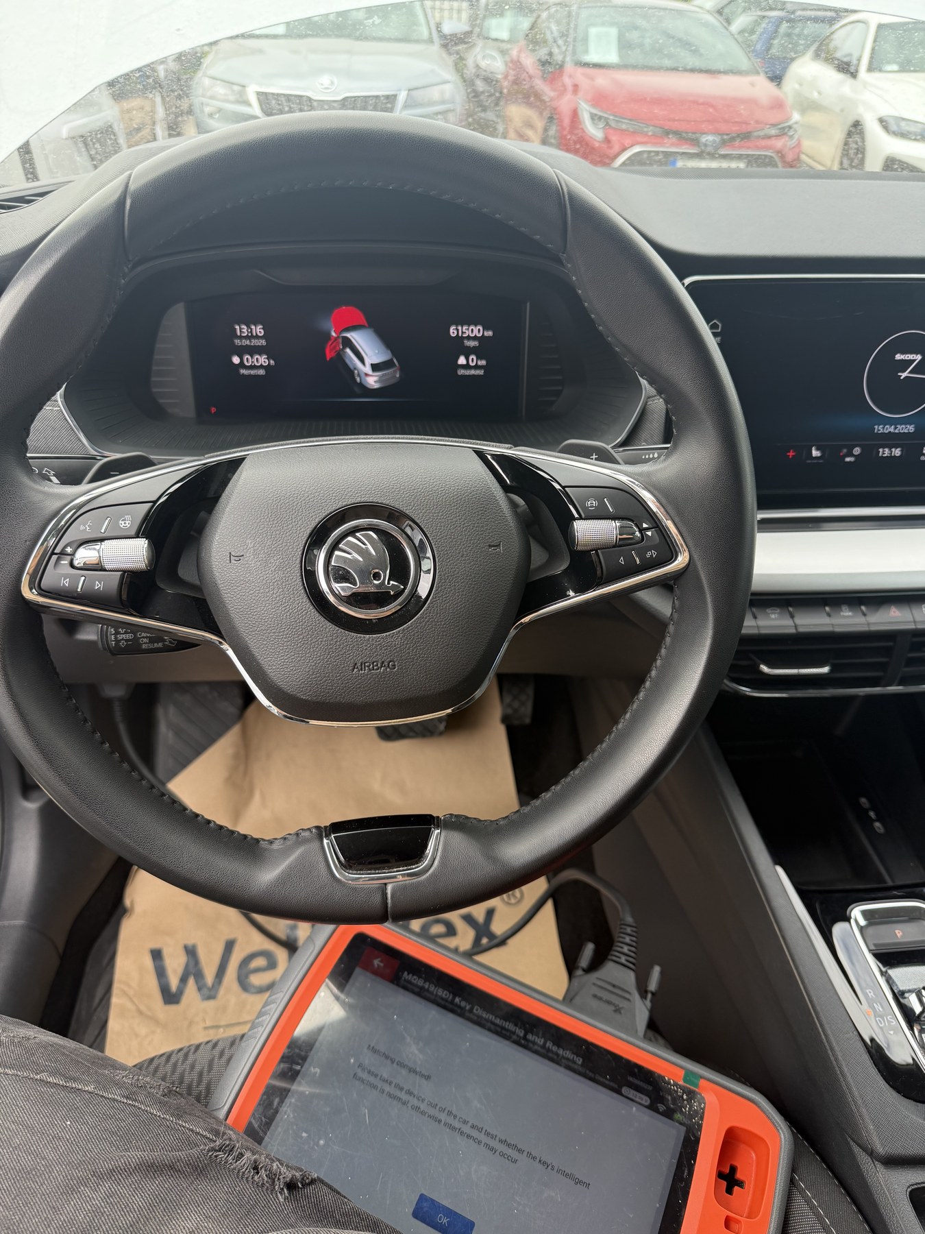 Škoda digitális műszerfala, előtte a diagnosztikai eszköz az indításgátló kiolvasása közben